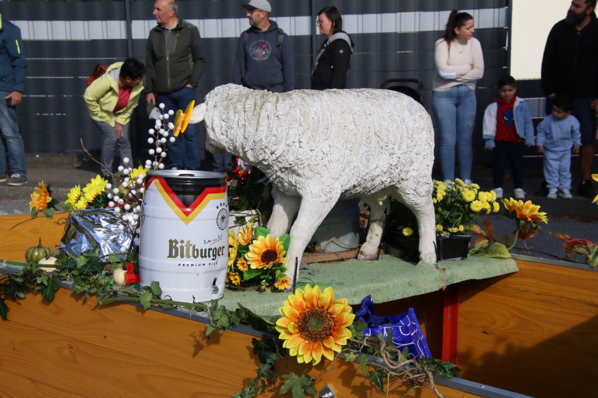 Schaffiguren und Blumen auf einem Festwagen beim Erntedankzug Walheim 2026.