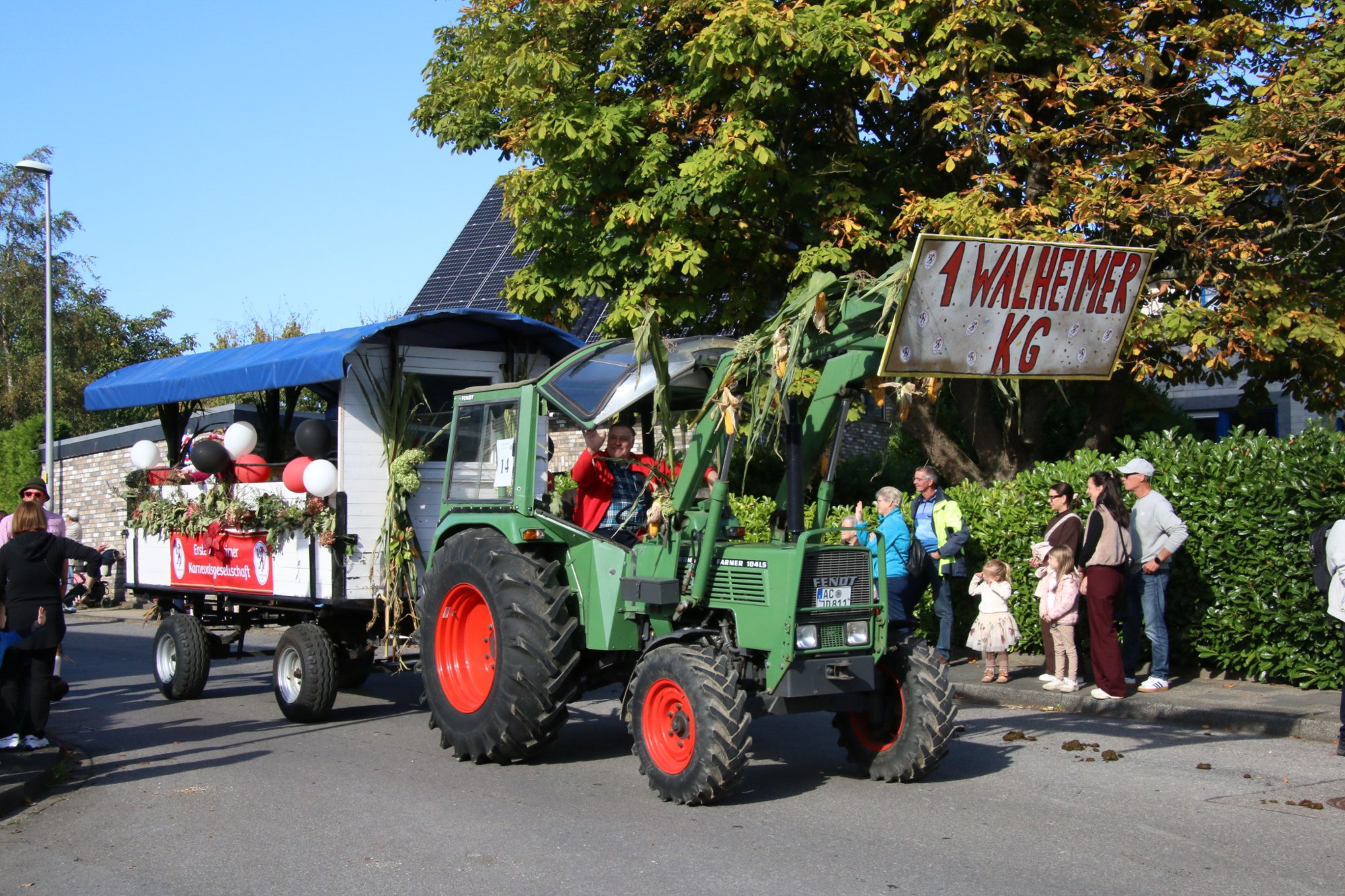 Traktor mit Festwagen vor Zuschauern beim Erntedankzug Walheim 2026.