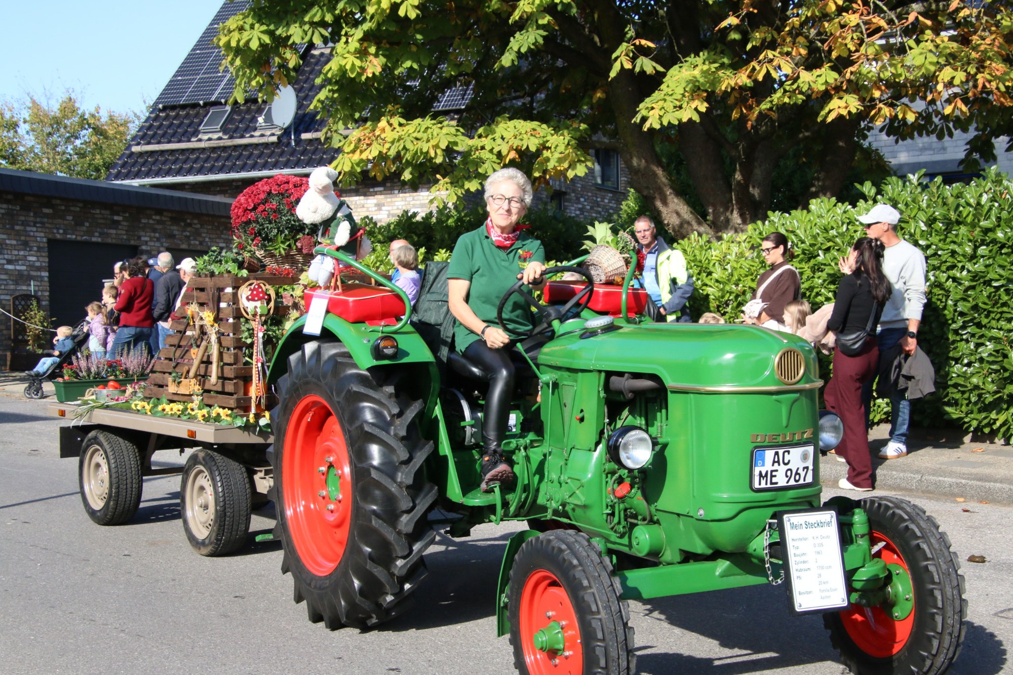 Grüner Oldtimertraktor mit rotem Fahrgestell beim Erntedankzug Walheim 2026.