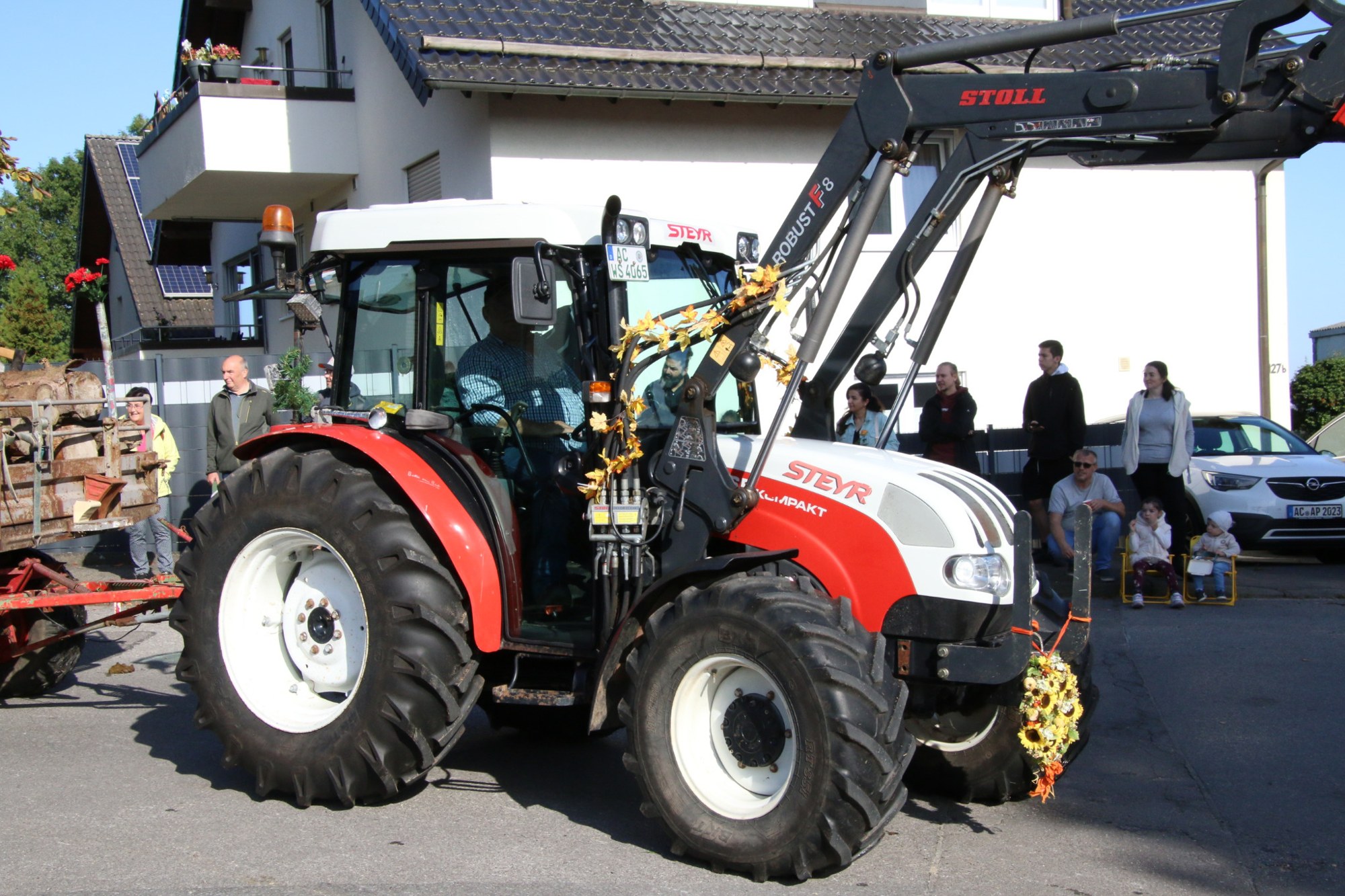 Rot-weißer Traktor auf der Zugstrecke beim Erntedankzug Walheim 2026.