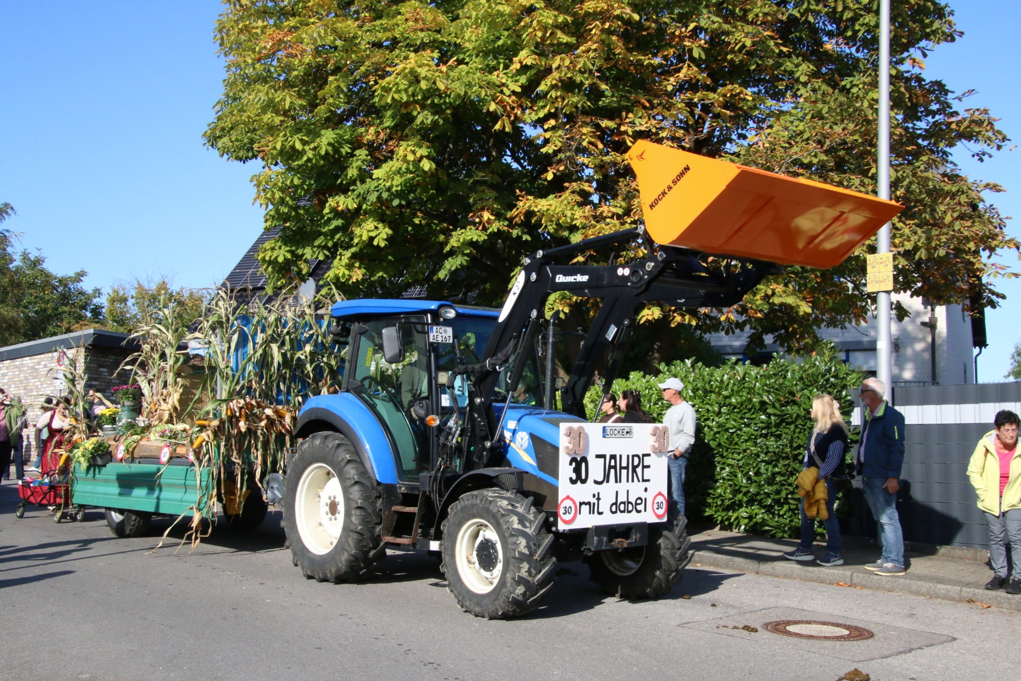 Blauer Traktor mit erhobener Schaufel beim Erntedankzug Walheim 2026.