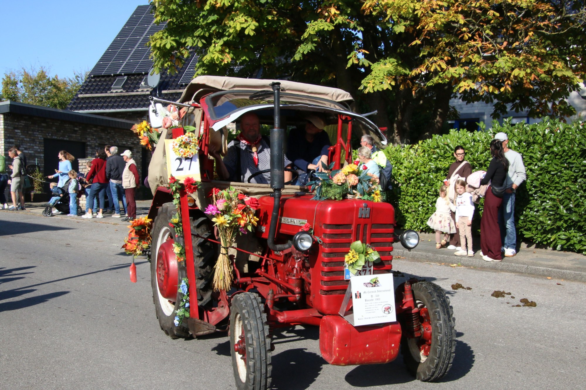 Roter Oldtimertraktor mit Blüten beim Erntedankzug Walheim 2026.