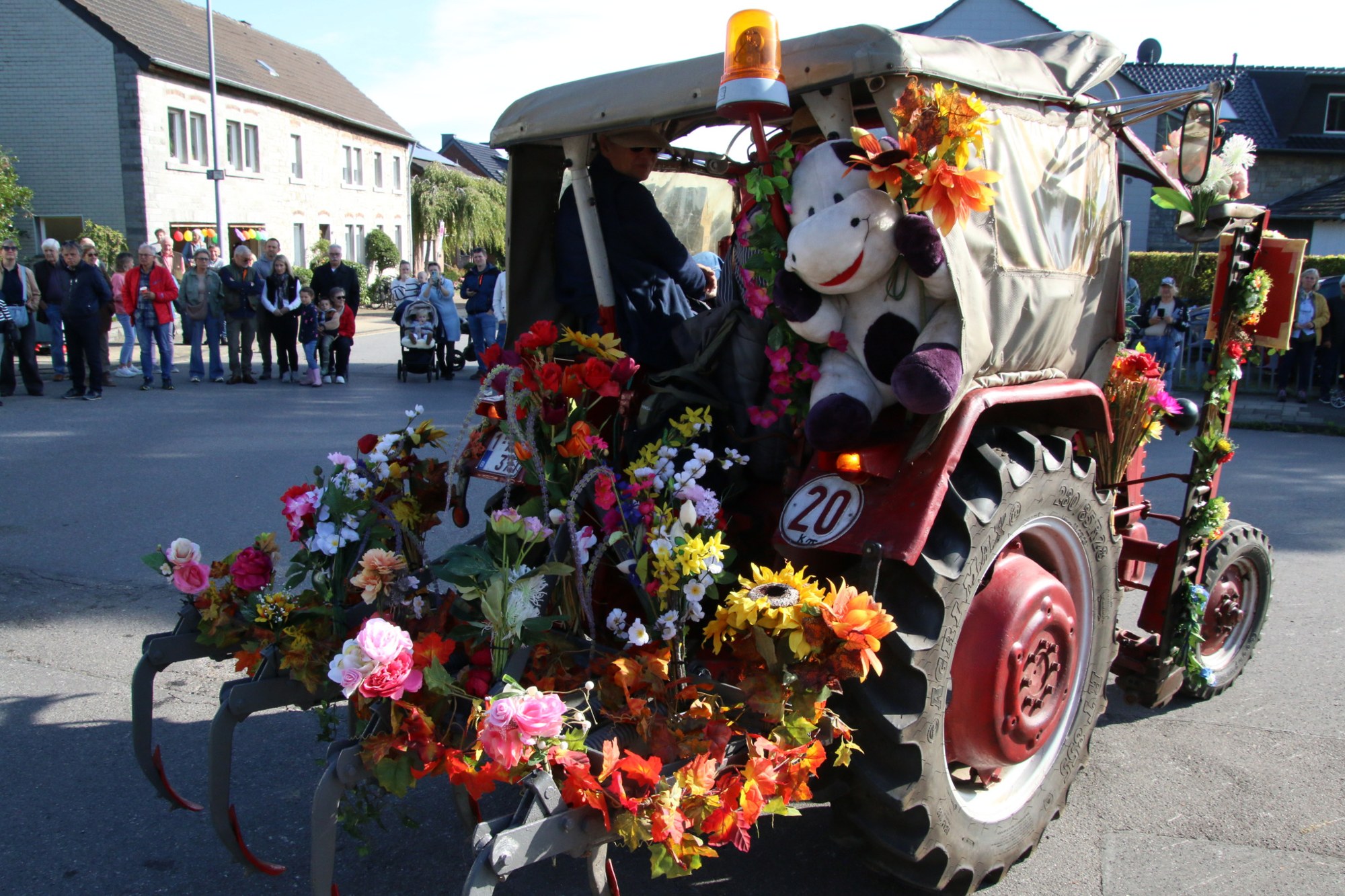 Teilnehmer im blumengeschmückten Traktor beim Erntedankzug Walheim 2026.