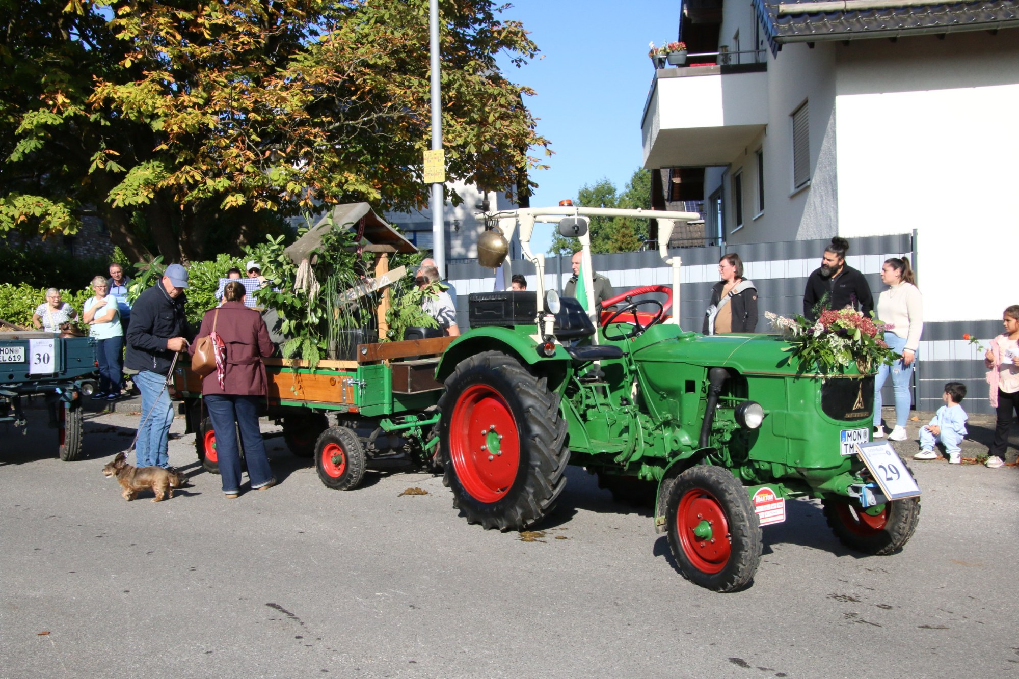 Grüner Traktor vor einem Wohnhaus beim Erntedankzug Walheim 2026.