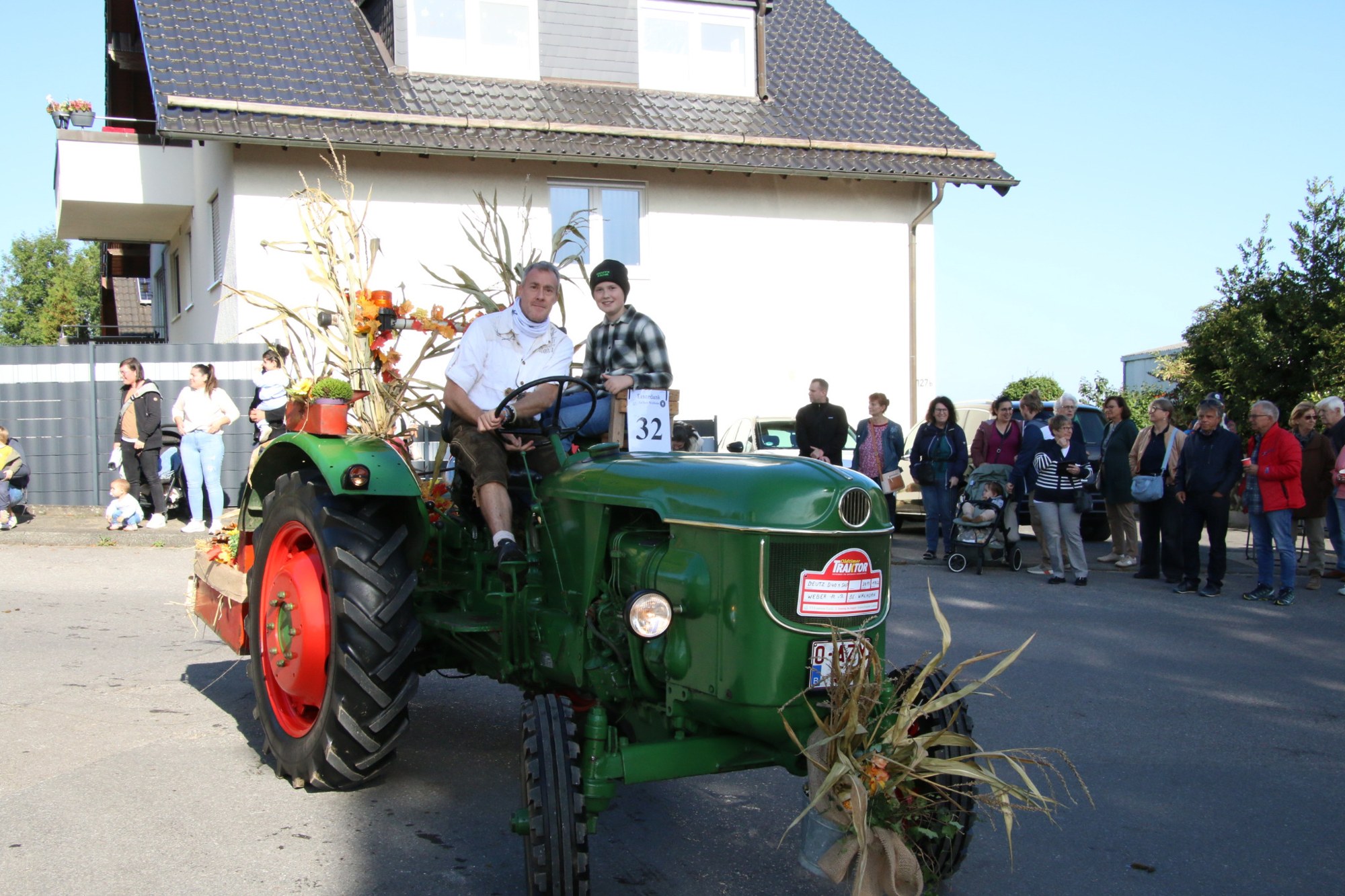 Grüner Traktor mit Strohdekoration beim Erntedankzug Walheim 2026.