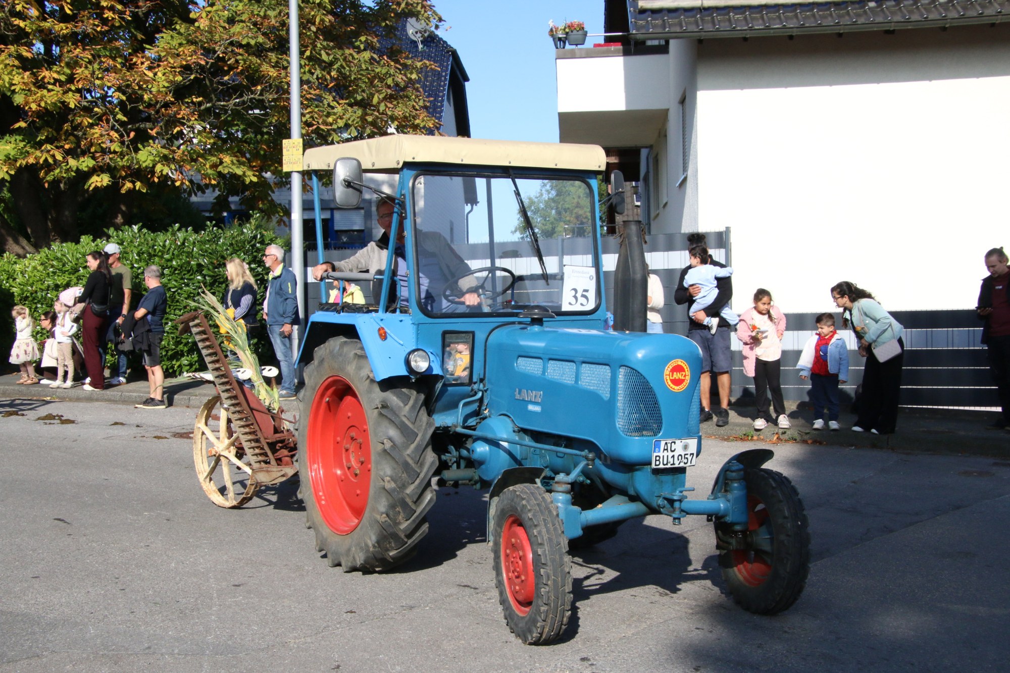 Blauer Traktor vor dem Publikum beim Erntedankzug Walheim 2026.