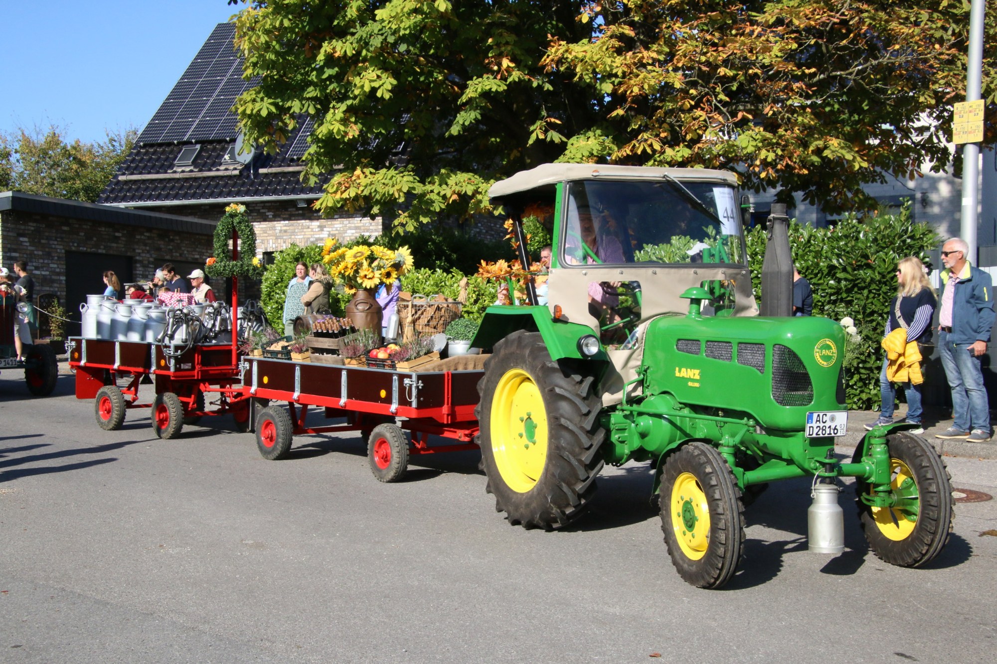 Grüner Traktor mit langem Anhänger beim Erntedankzug Walheim 2026.