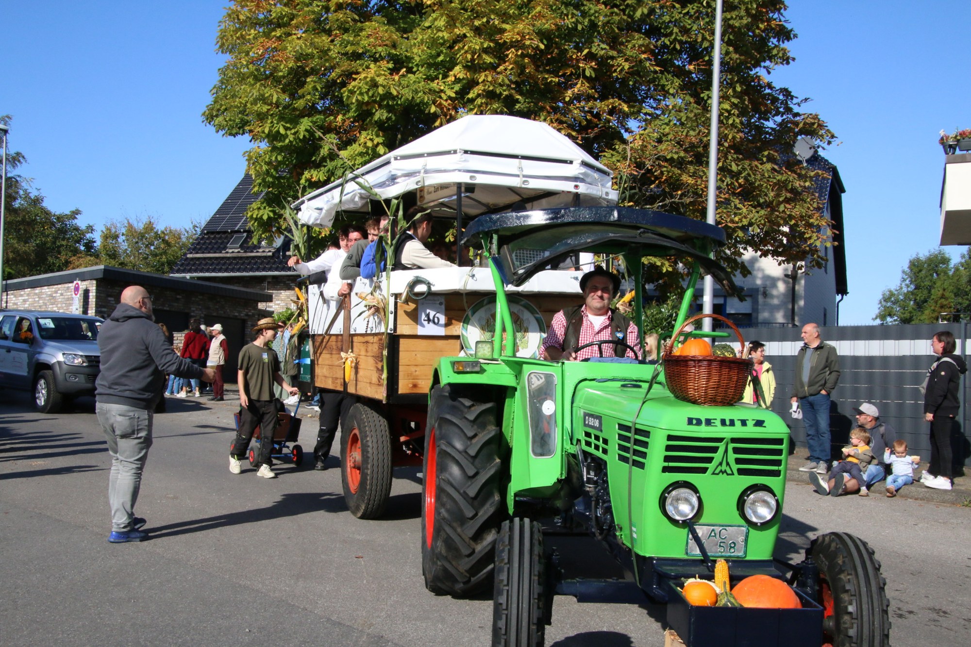 Grüner Traktor mit überdachtem Wagen beim Erntedankzug Walheim 2026.