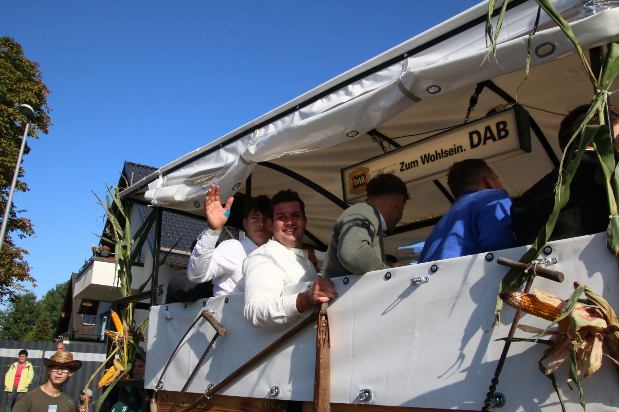 Teilnehmer unter dem Dach eines Festwagens beim Erntedankzug Walheim 2026.
