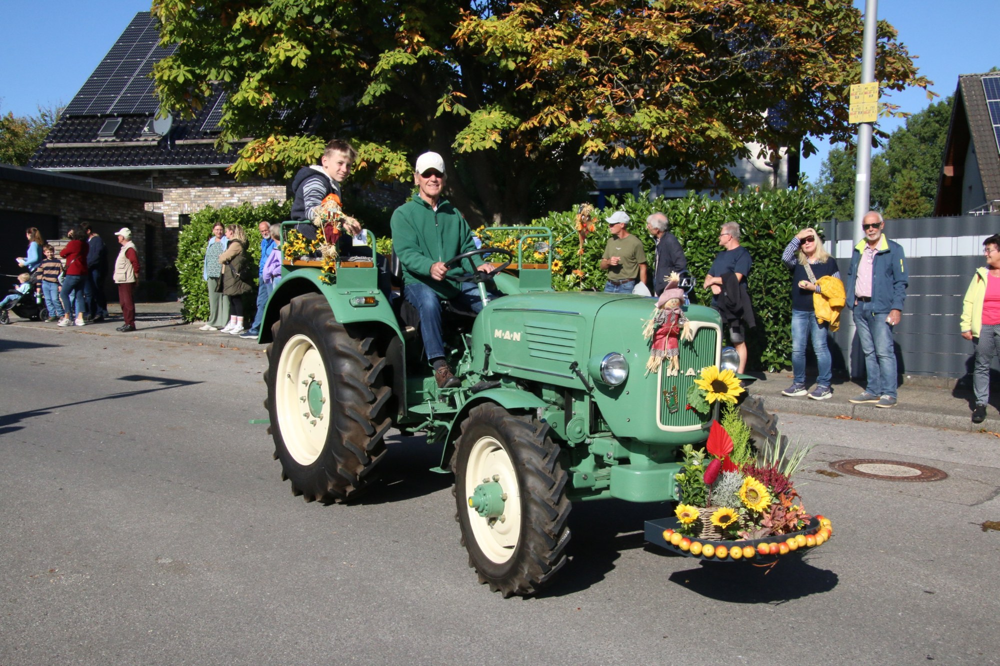Traktor mit Blumenschmuck am Kühler beim Erntedankzug Walheim 2026.