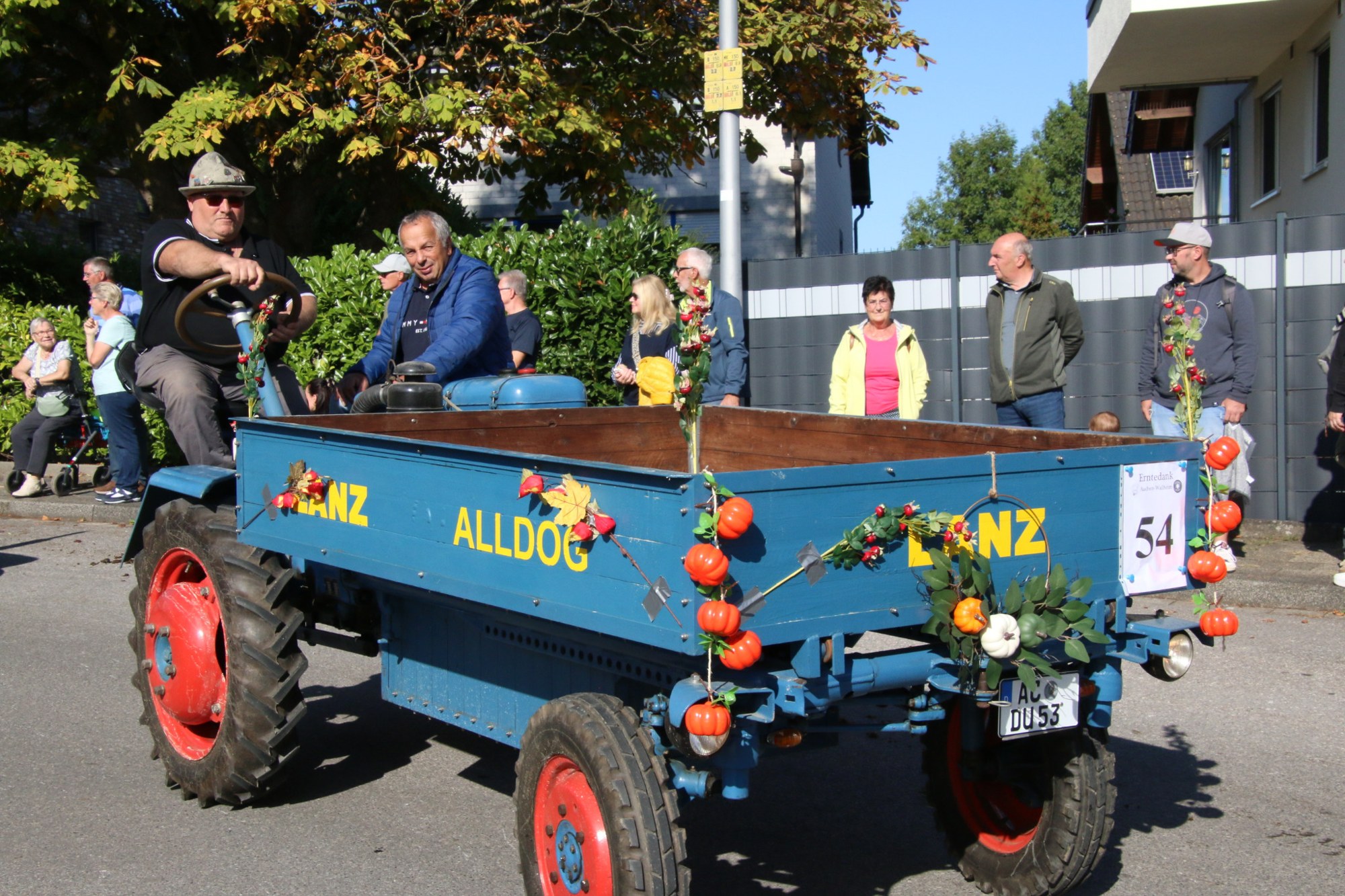 Teilnehmer auf einem blauen Anhänger beim Erntedankzug Walheim 2026.