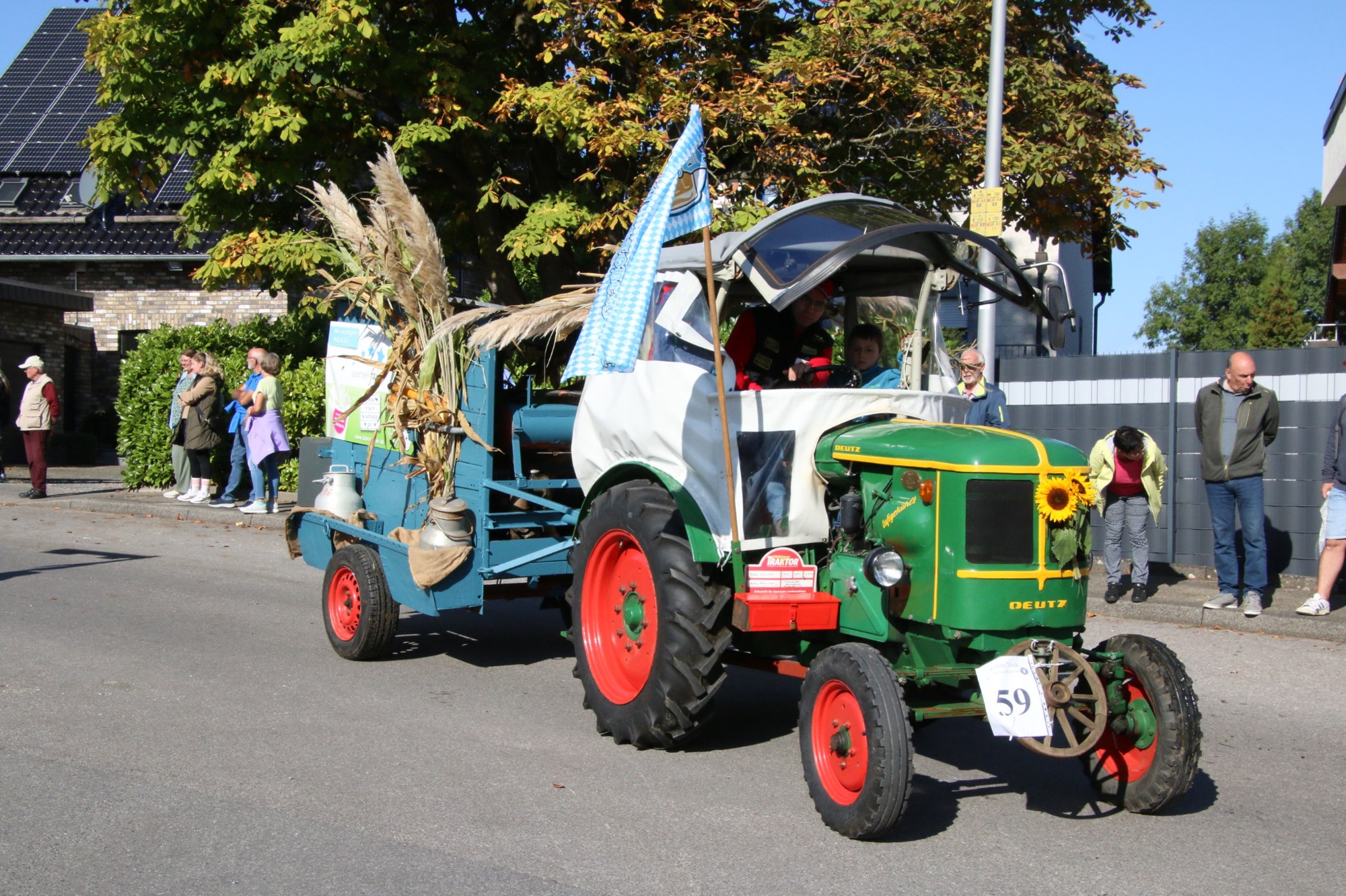 Grüner Traktor mit blauem Anhänger beim Erntedankzug Walheim 2026.