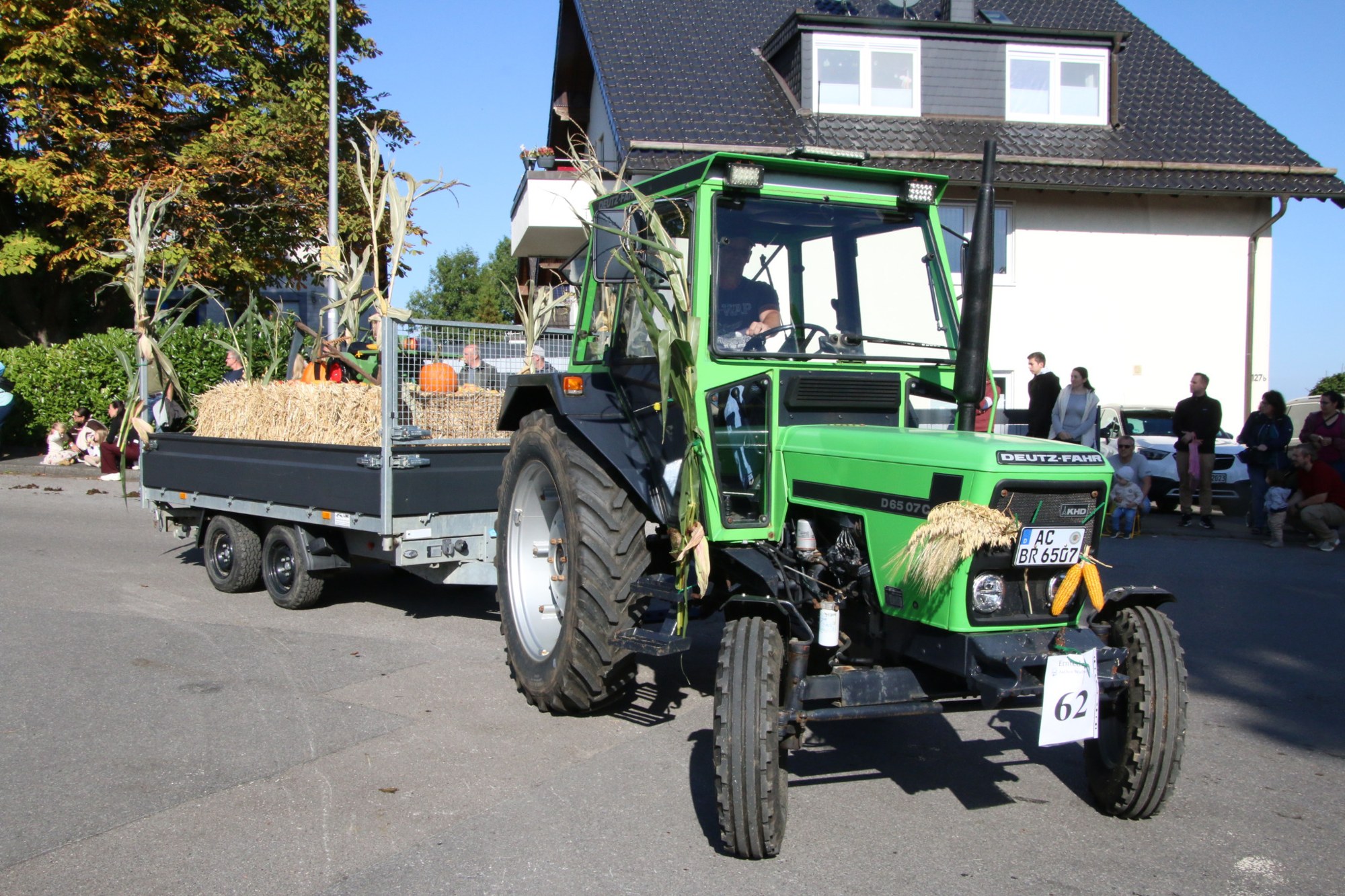 Grüner Traktor mit Anhänger vor Zuschauern beim Erntedankzug Walheim 2026.