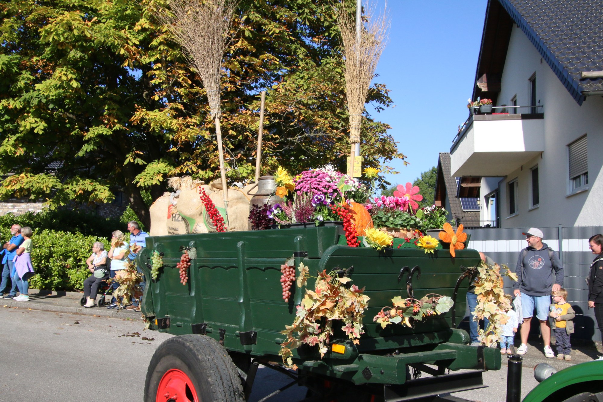 Grüner Erntewagen mit Herbstblumen beim Erntedankzug Walheim 2026.