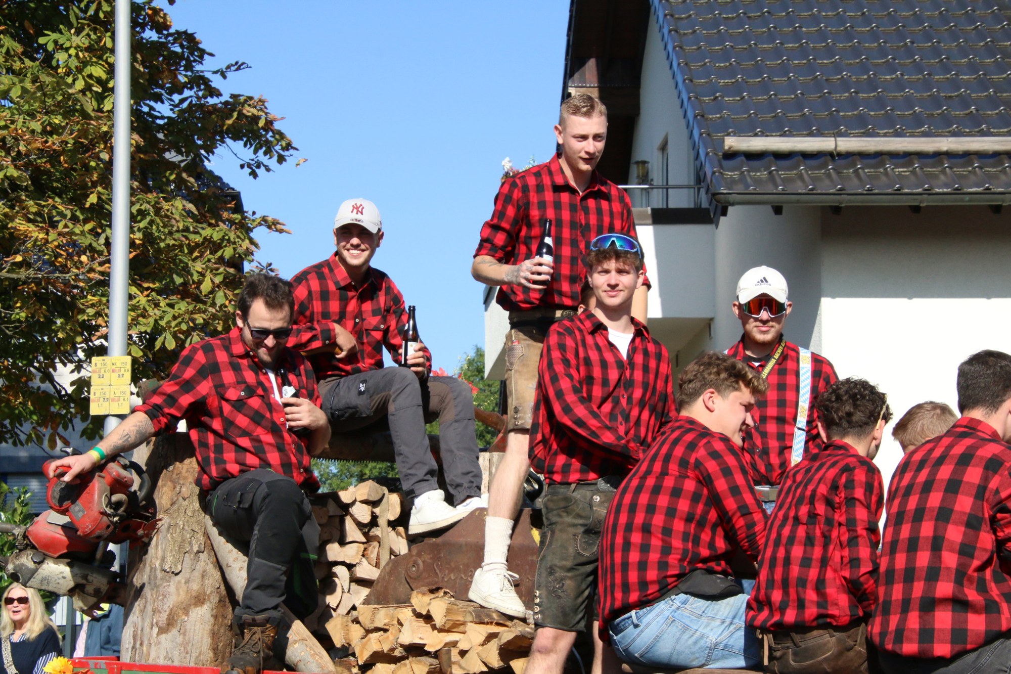 Teilnehmer in rot karierten Hemden auf einem Festwagen beim Erntedankzug Walheim 2026.