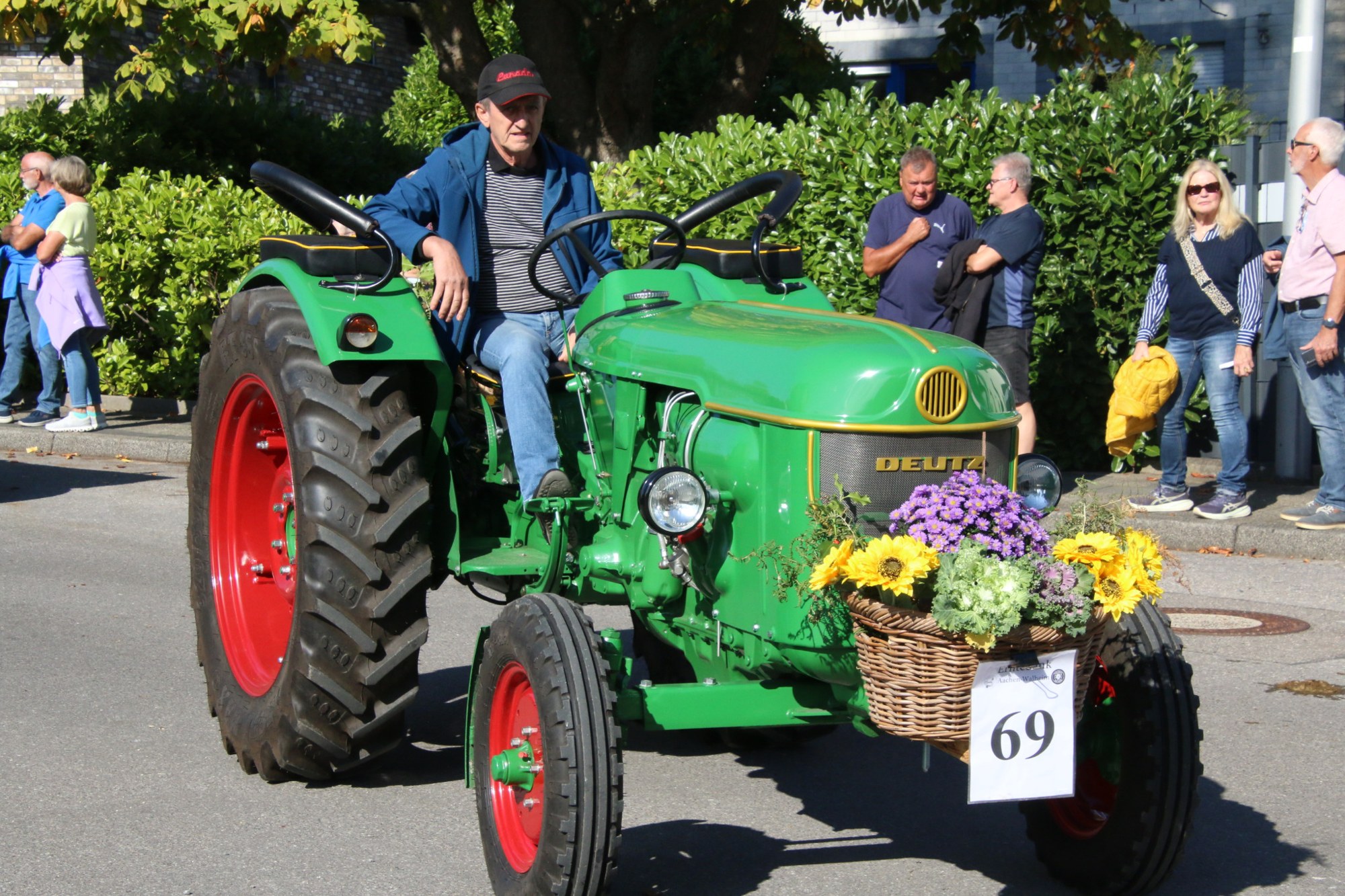 Grüner Traktor mit Blumen und Teilnehmern beim Erntedankzug Walheim 2026.