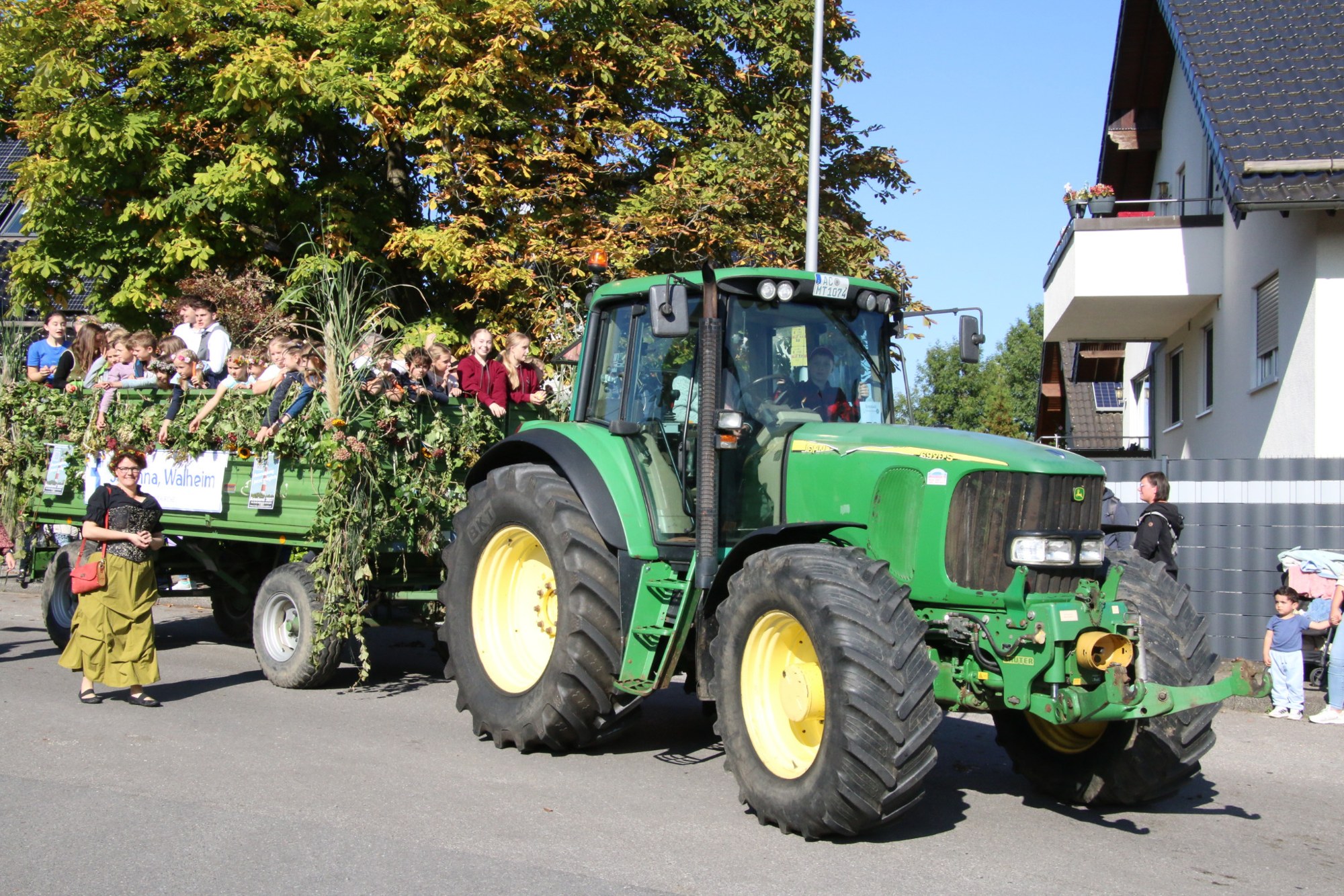 Grüner Traktor mit großem Festwagen beim Erntedankzug Walheim 2026.