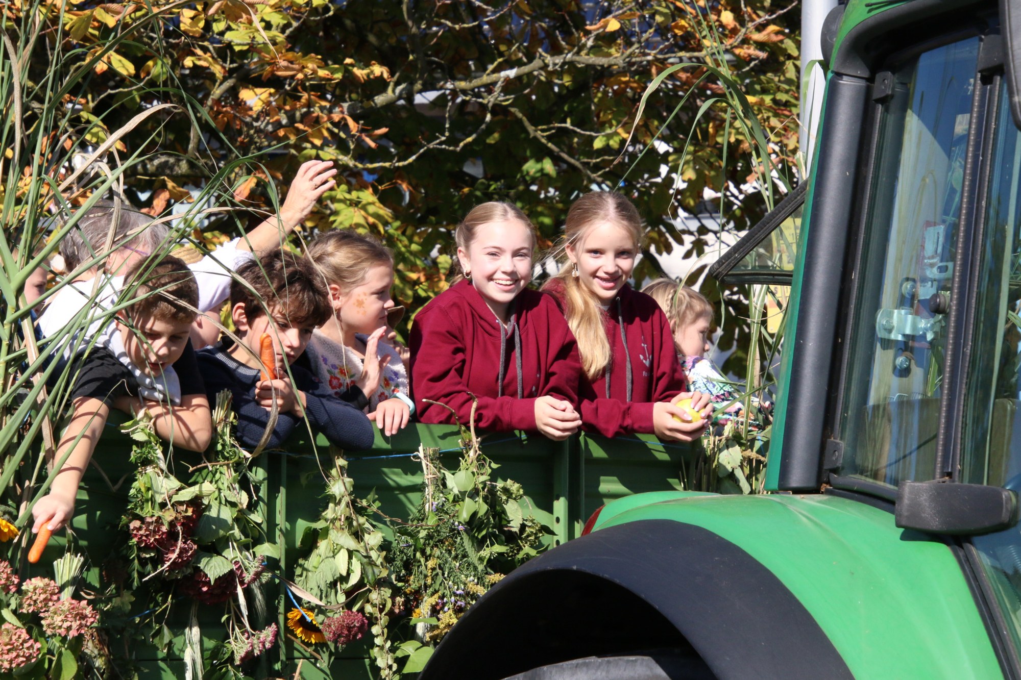 Teilnehmer auf einem begrünten Wagen beim Erntedankzug Walheim 2026.